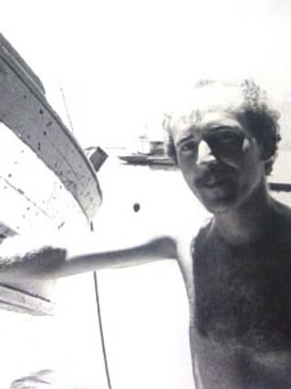 Luiz Fernando Dias Duarte jovem, sem camisa, junto ao casco de um barco em Jurujuba, em 1975.